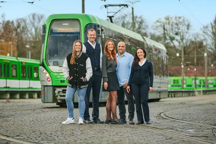 Team der ÜSTRA vor grüner Stadtbahn am Betriebshof Hannover